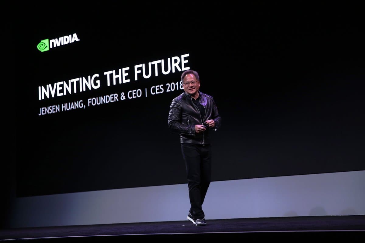 Nvidia founder and CEO Jensen Huang on stage in a black leather jacket in front of an Inventing the Future backdrop