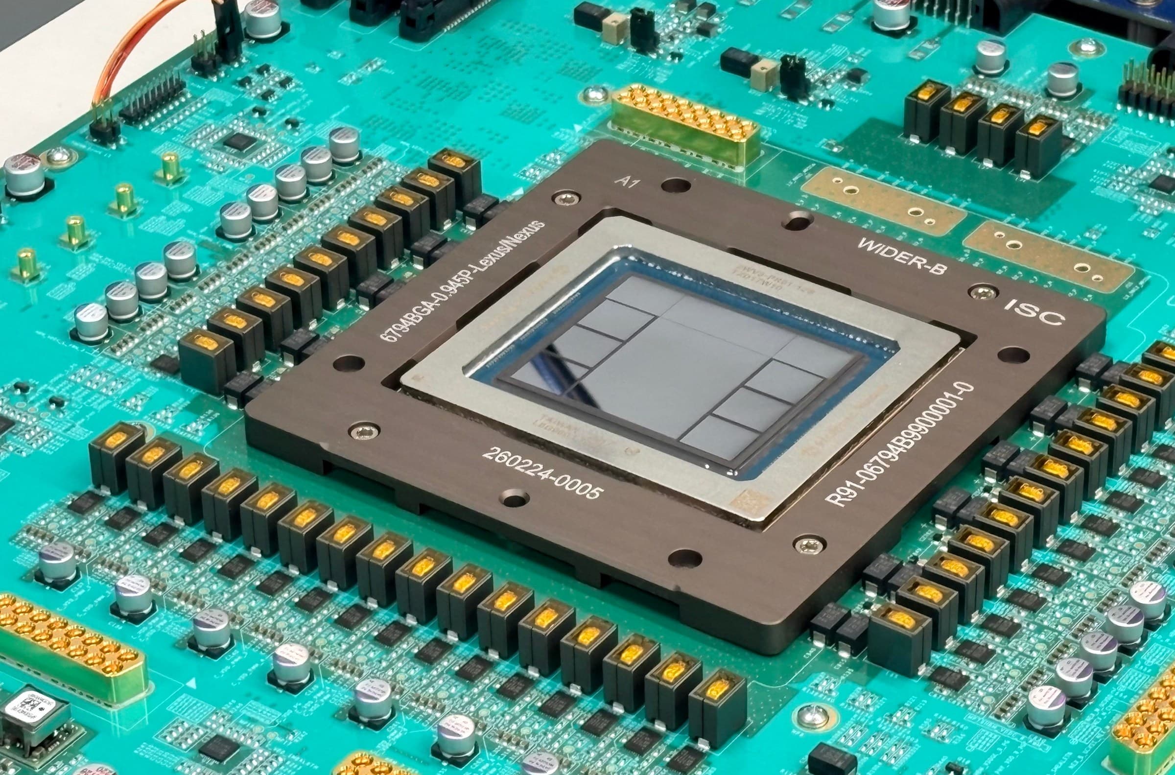 Close-up of OpenAI's Jalapeño inference accelerator mounted in a metal BGA frame on a teal circuit board