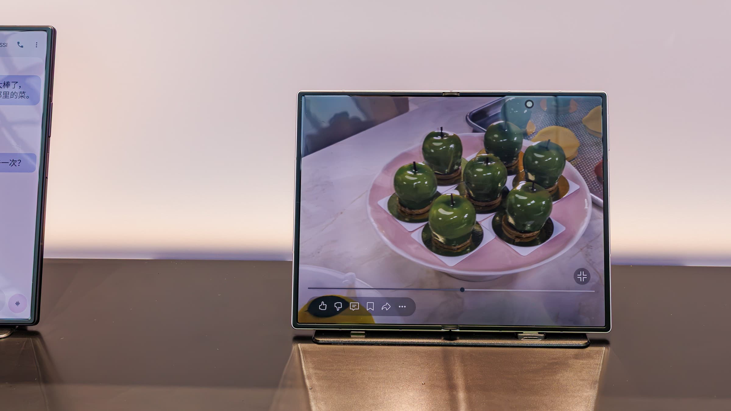 A Samsung Galaxy Z Fold 8 unfolded on a small stand, its inner display showing a photo of green apple-shaped desserts