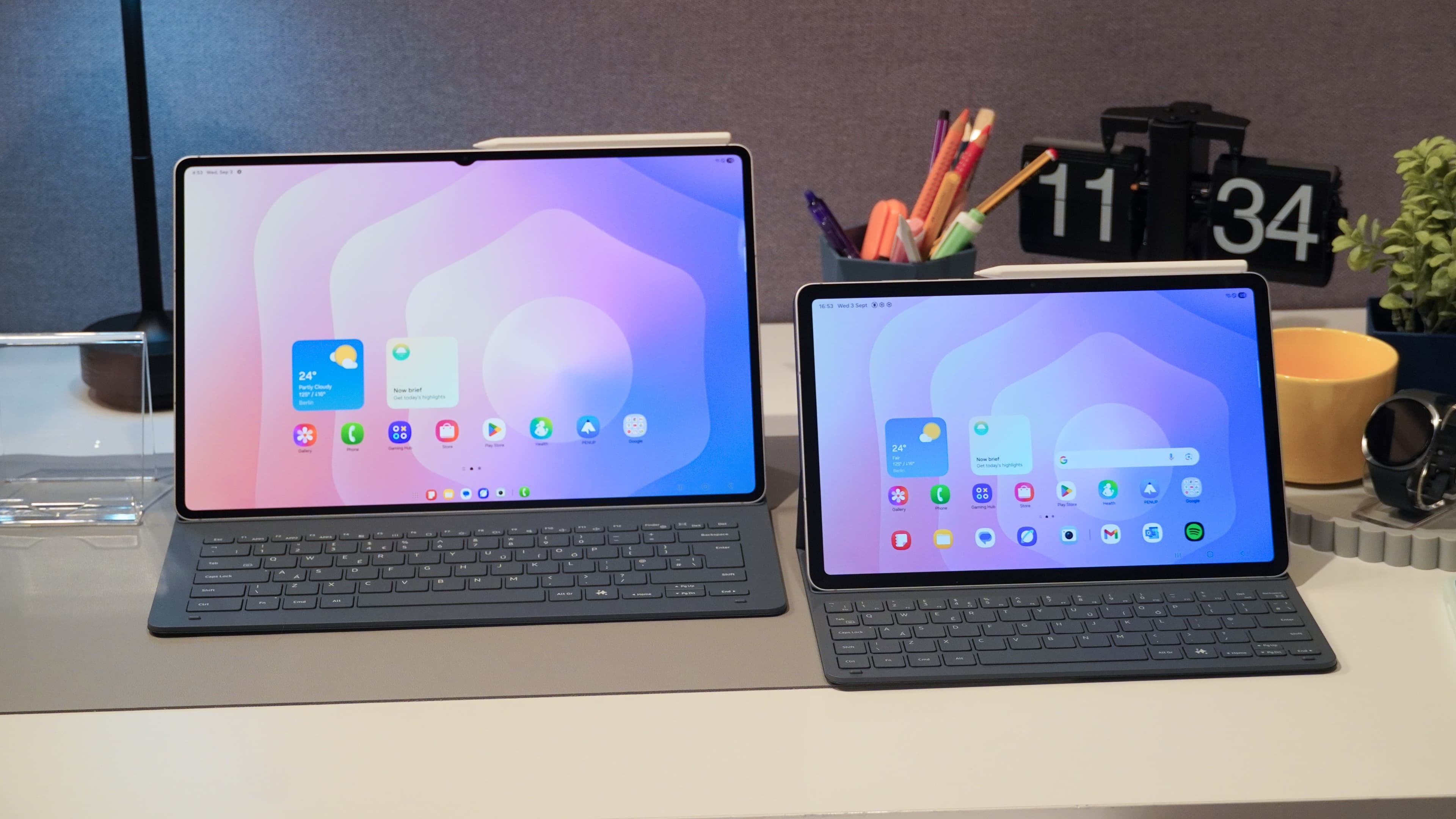Samsung Galaxy Tab S12 Ultra and Tab S12+ side by side on a desk with Book Cover keyboards and white S Pens attached
